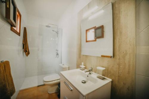 łazienka z umywalką, toaletą i lustrem w obiekcie Agradable y familiar, con piscina "Casa Inima" w mieście Playa Blanca