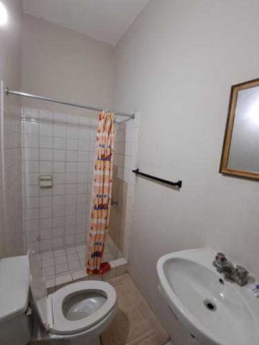 a bathroom with a toilet and a sink at Mom's Place Negril in Negril