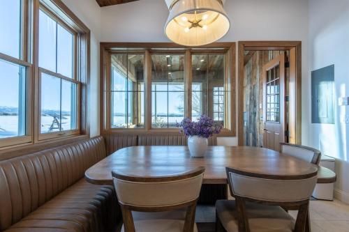 a dining room with a table and chairs and windows at Historic Homestead with Pond and Teton Range Views in Tetonia