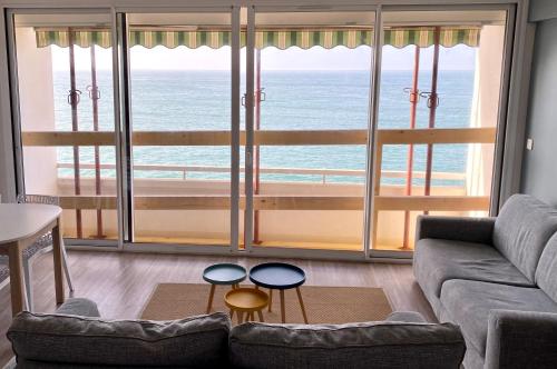 un salon avec vue sur l'océan dans l'établissement Appartement vue mer panoramique, à Étretat