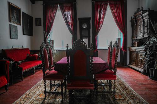 a dining room with a table and chairs and a clock at Zamek Usobi in Úsobí