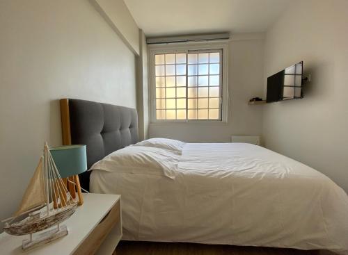 une chambre avec un lit et une fenêtre dans l'établissement Appartement vue mer panoramique, à Étretat