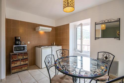 une salle à manger avec une table et des chaises en verre dans l'établissement La Bellevue en plein du coeur centre-ville avec wifi, à Millau