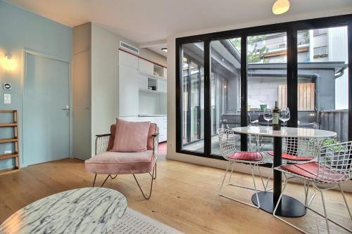 un salon avec une table et des chaises dans l'établissement PARISIAN HOME l MARAIS, à Paris