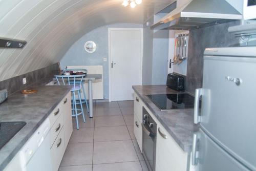 a kitchen with a white refrigerator and a table at Gite l'anemone in Saint-Pierre-des-Tripiers
