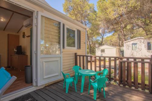 a porch with a table and chairs on a deck at Mobilhome Oasis village Puget in Puget-sur Argens