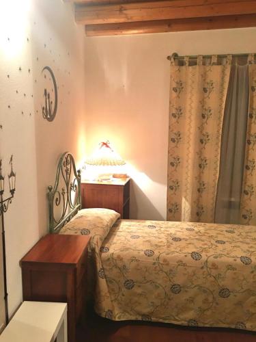 a bedroom with a bed and a table with a lamp at Agriturismo Corte Marani in Badia Calavena