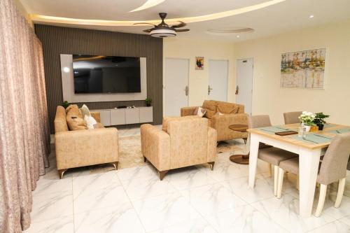 a living room with chairs and a table and a television at Everyone deserves to rest from their labor in Kweman