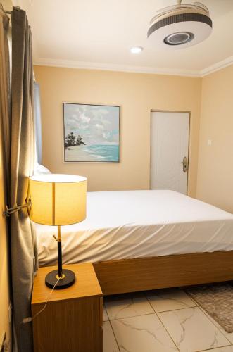 a bedroom with a bed and a lamp at Everyone deserves to rest from their labor in Kweman