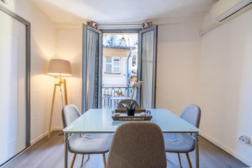 une salle à manger avec une table et des chaises et une fenêtre dans l'établissement Vieux-Nice 2P climatisé Balcon, à Nice