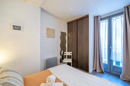 une chambre avec un lit et une grande fenêtre dans l'établissement Vieux-Nice 2P climatisé Balcon, à Nice