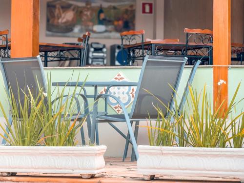 two chairs and a table and chairs and plants at Pousada Quinta dos Colibris in São Bento do Sapucaí