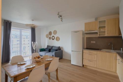 Il dispose d'une cuisine et d'un salon avec une table et des chaises en bois. dans l'établissement La Source - A 20 minutes à pied du centre, à Nantes