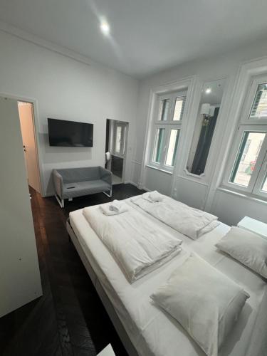 a white bedroom with a large bed and a tv at Notorious Design Apartments - near Kärntner Straße in Vienna