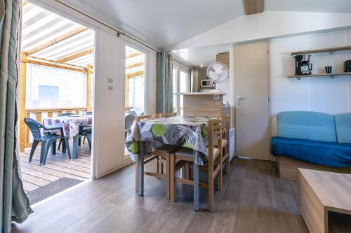 une petite chambre avec une table et une salle à manger dans l'établissement Mobil home camping siblu, à Saint-Jean-de-Monts