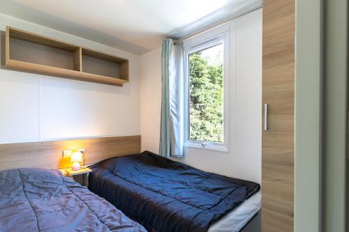 une chambre avec un lit et une fenêtre dans l'établissement Mobil home camping siblu, à Saint-Jean-de-Monts