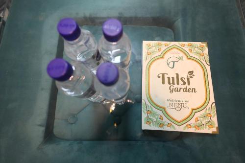 a group of water bottles with purple caps next to a sign at The Tulsi Garden - Ashram vihar vrindavan in Vrindāvan