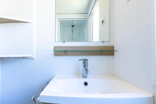 une salle de bain avec un lavabo et un miroir dans l'établissement Mobil home camping siblu, à Saint-Jean-de-Monts