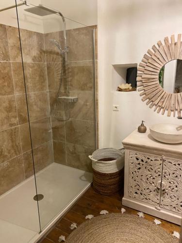 une salle de bain avec une douche, un lavabo et un miroir dans l'établissement Mas de Sophie, à Châteaurenard