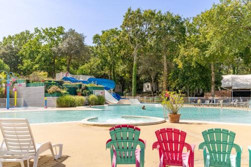- un groupe de chaises en face d'une piscine dans l'établissement Mobil home 8 personnes, à Saint-Brévin-les-Pins