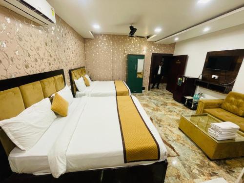a hotel room with a large bed and a couch at The Tulsi Garden - Ashram vihar vrindavan in Vrindāvan