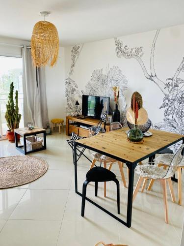 un salon avec une table et des chaises dans l'établissement T3 cosy - grande terrasse en accès direct à la mer, à Fleury