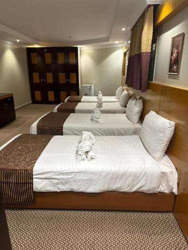 a group of four beds in a hotel room at فندق المغاربي للشقق الفندقية in Al Madinah