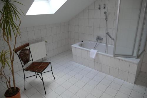 ein Badezimmer mit einem Stuhl und einer Badewanne in der Unterkunft Hotel Am Dom in Greifswald