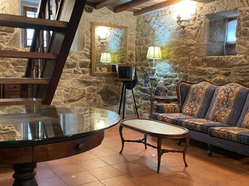 a living room with a couch and a glass table at Val Fresco Suites & Relax - casa rural in Curantes