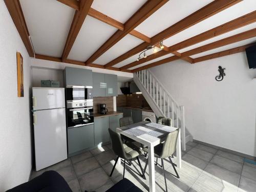 Il comprend une cuisine et une salle à manger avec une table et un réfrigérateur. dans l'établissement Villa T3 avec terrasse, 6 couchages, proche plage et commerces, quartier calme, parking privé - FR-1-81-365, à Port-Leucate