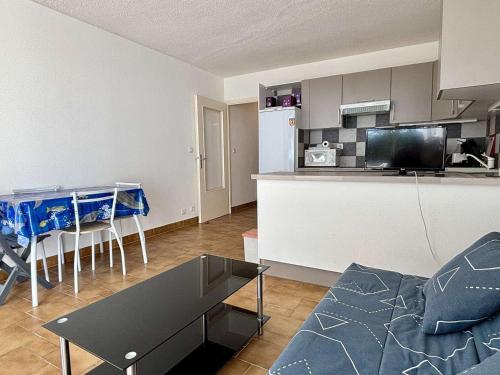 un salon avec un canapé et une table et une cuisine dans l'établissement Studio cabine cosy avec terrasse et accès direct plage, Argelès-sur-Mer - FR-1-225-595, à Argelès-sur-Mer