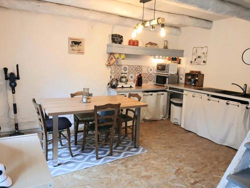 une cuisine avec une table et des chaises en bois dans l'établissement Maison de campagne 60m2, à Tailhac