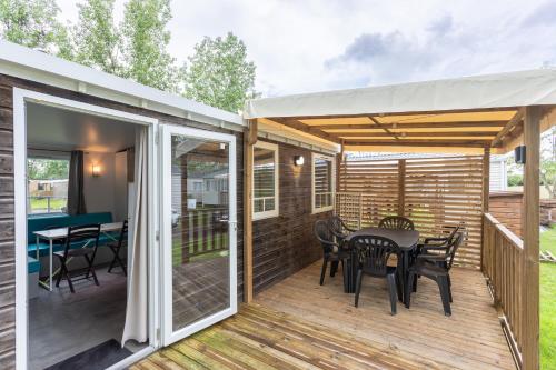 a patio with a table and chairs on a deck at Mobil-home in Angles