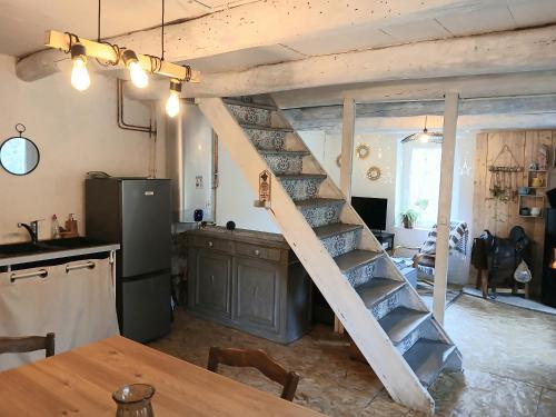 une cuisine avec un escalier au milieu d'une pièce dans l'établissement Maison de campagne 60m2, à Tailhac