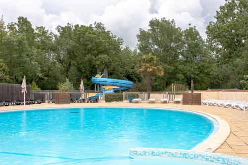 a swimming pool with a slide in a resort at Mobil-home in Angles