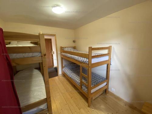 une chambre avec plusieurs lits superposés dans une pièce dans l'établissement F4 bas de chalet avec terrasse et parking - Les Angles - FR-1-295-143, aux Angles