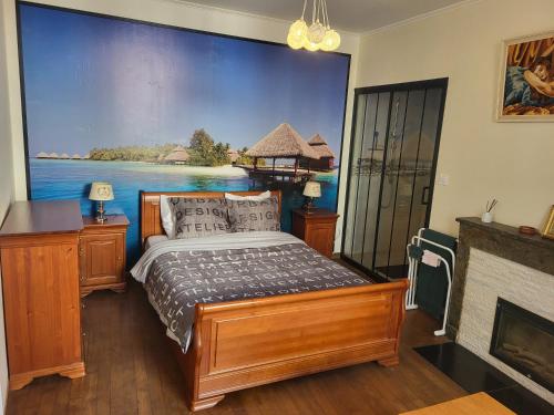 a bedroom with a bed with a painting on the wall at Gîte Chez Angela in Bar-sur-Aube