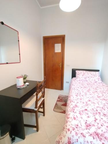 a bedroom with a bed and a desk and a table and a bed at La casa di Morena in Torre del Lago Puccini