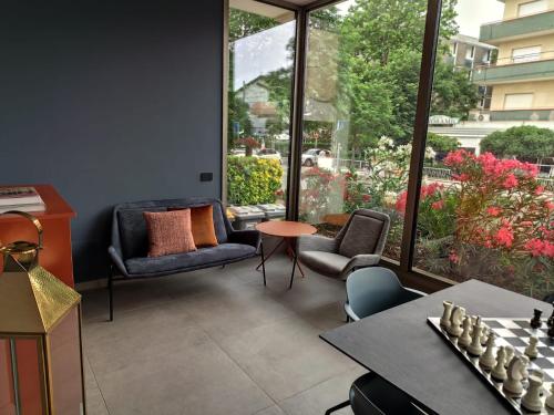 a living room with chairs and tables and a large window at Hotel Sporting Riccione in Riccione