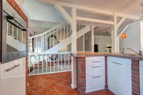 a kitchen with white cabinets and a staircase at Haus Kieferngrund in Ahlbeck