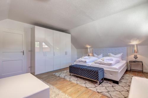 a bedroom with two beds with white walls at Haus Kieferngrund in Ahlbeck