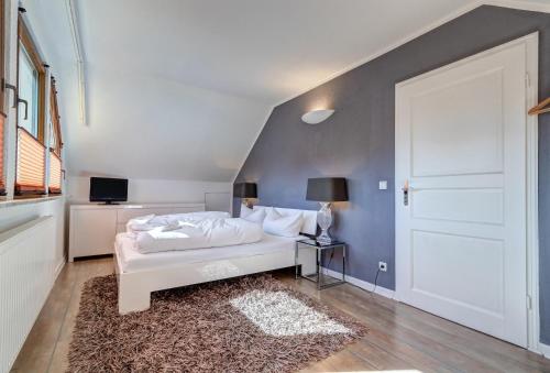 a bedroom with a white bed and a blue wall at Haus Kieferngrund in Ahlbeck