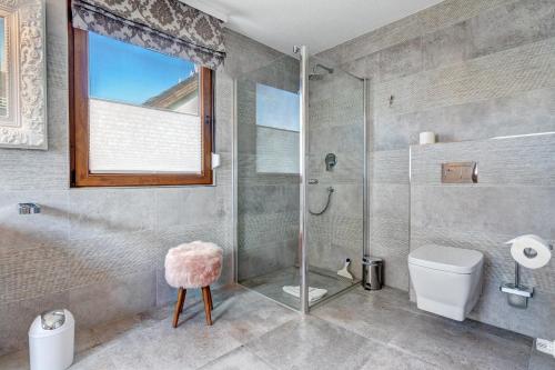 a bathroom with a shower and a toilet and a window at Haus Kieferngrund in Ahlbeck