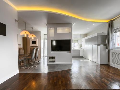 a living room with a television and a dining room at I Ludovici Luxury B&B in Casoria