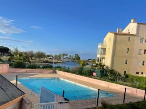une grande piscine à côté d'un immeuble dans l'établissement Joli T2 avec terrasse, piscine, proche plage pour 4 pers - FR-1-607-172, au Cap d'Agde