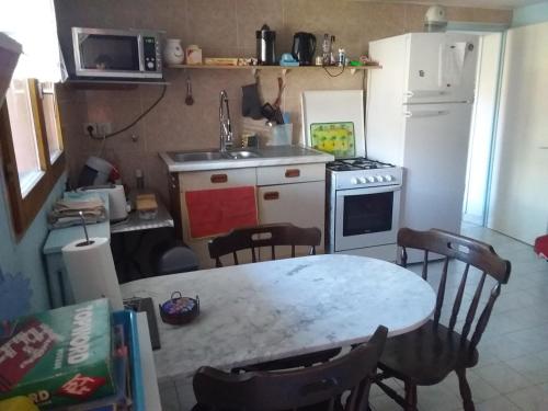 Il comprend une petite cuisine avec une table et un réfrigérateur blanc. dans l'établissement Chez Lisa, à Saint-Georges-de-Commiers