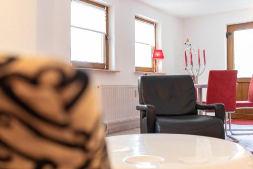ein Raum mit Tisch und Stühlen und Fenstern in der Unterkunft Ferienwohnung Kieferngrund in Ahlbeck
