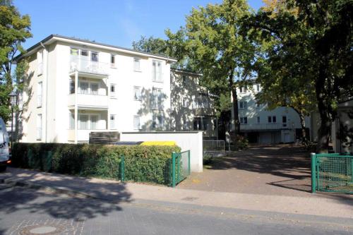 a white building with a green fence in front of it at Strandoase - FeWo 21 in Bansin