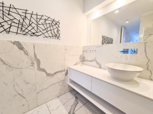 Un baño blanco con lavabo y espejo. en Ferienwohnung Lieblingssuite am Strand, en Ahlbeck