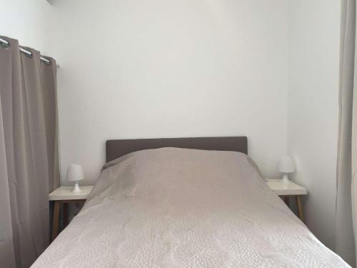 - une chambre avec un lit et 2 lampes sur les tables dans l'établissement Charmant T1 rénové avec terrasse, climatisation et WiFi à Balaruc-les-Bains - FR-1-553-282, à Balaruc-les-Bains